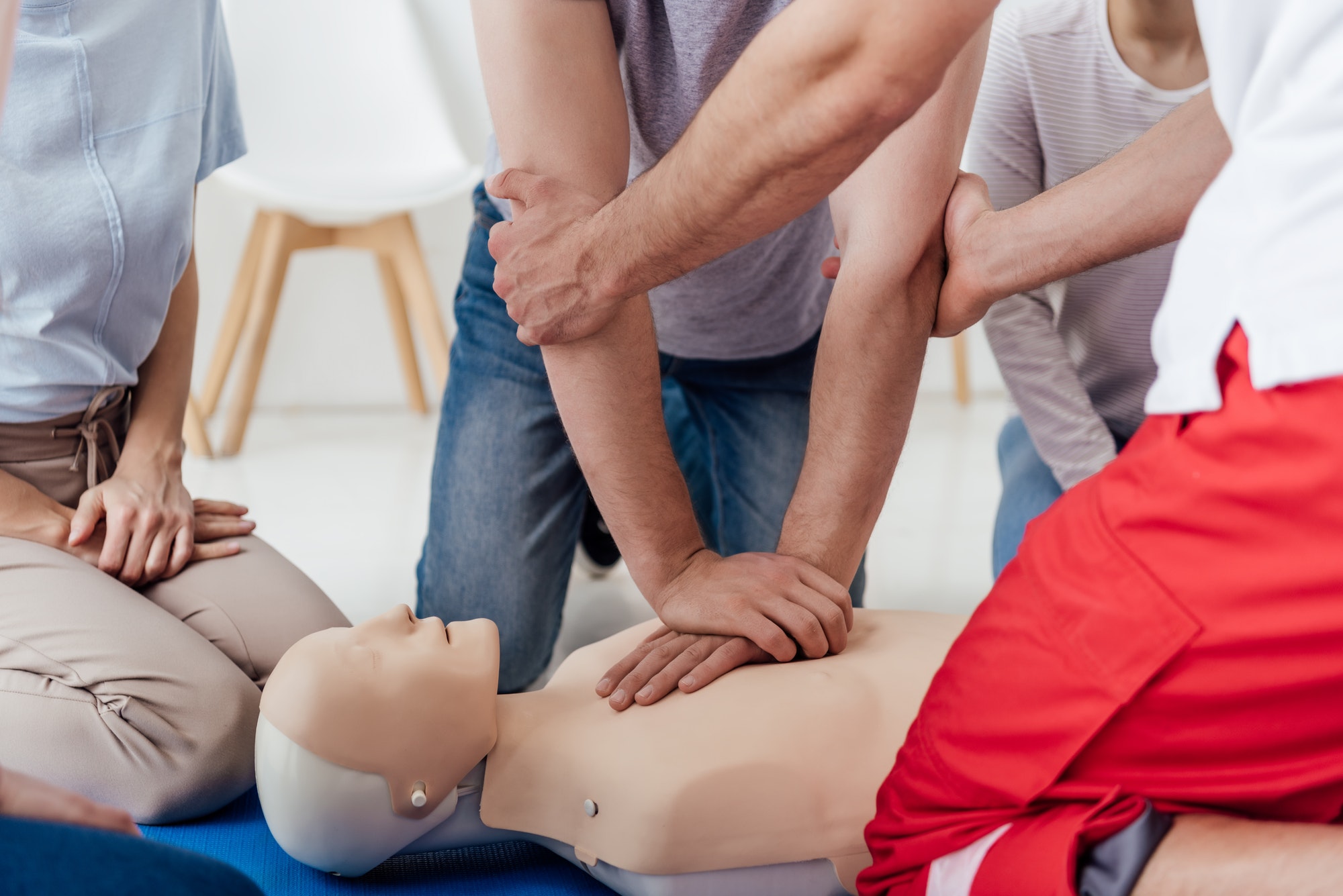 cropped view of group of people during first aid training with dummy