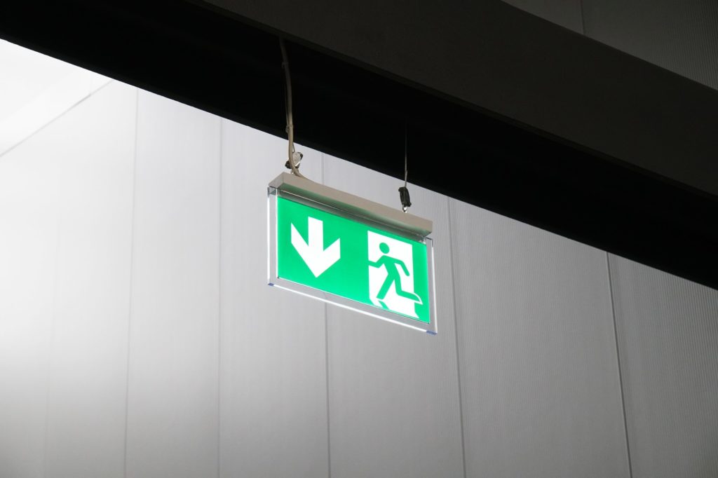 emergency exit or fire escape sign with green running man symbol